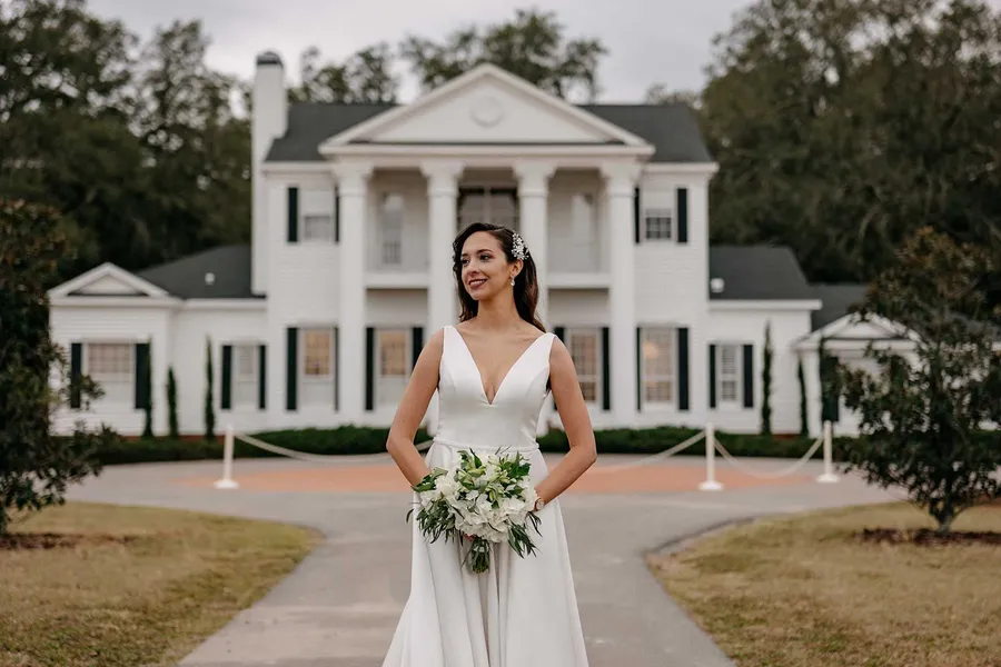 Marilia with her bouquet on the drive in front of the house