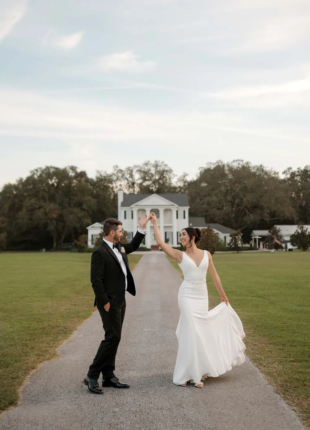Gabryelle and Dominick celebrating on the lawn in front of the estate house