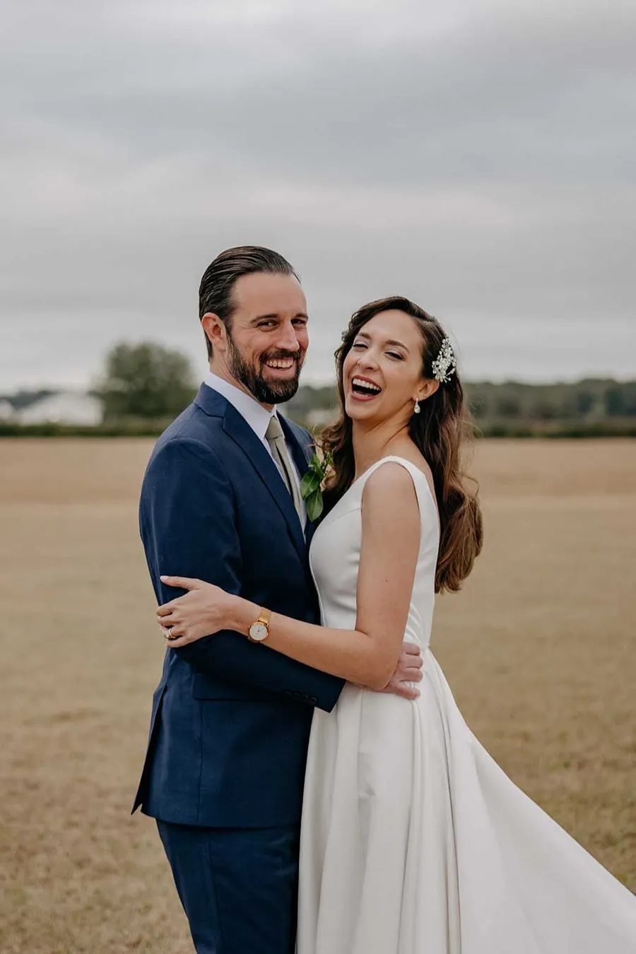 Matt and Marilia laughing together in the field